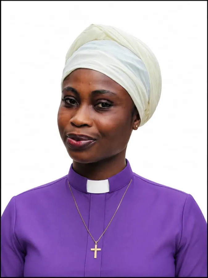 First-cohort student wearing a white headwrap and purple clerical shirt