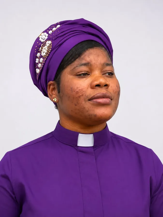 First-cohort student wearing a purple headwrap and clerical shirt