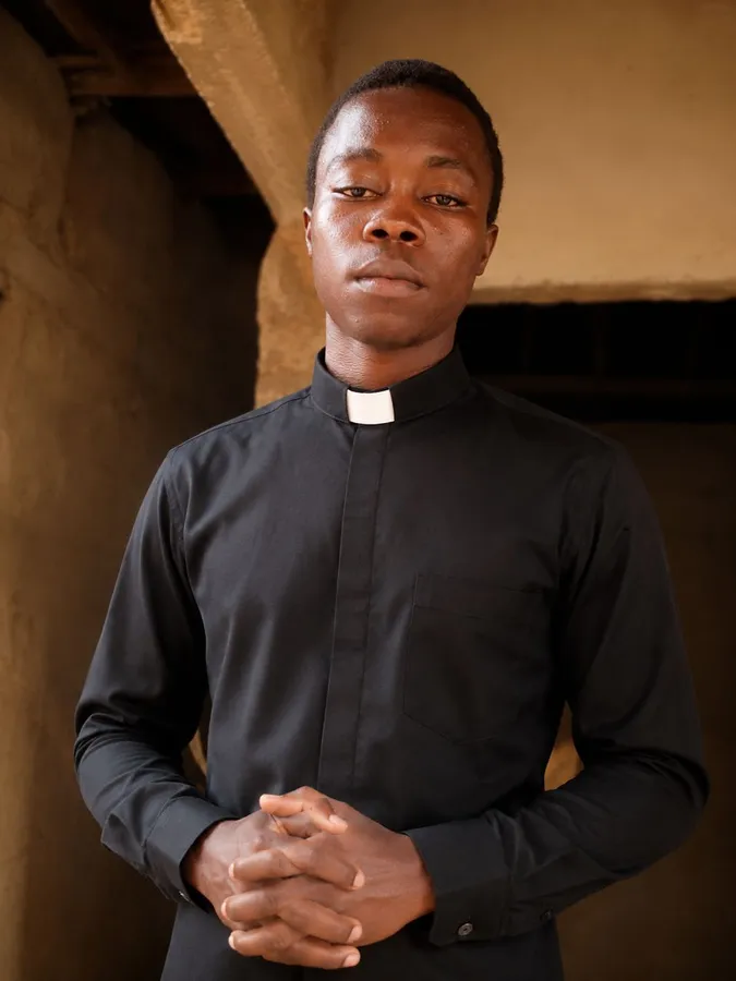 First-cohort student in black clerical attire